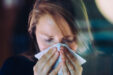 Woman Sneezing Behind A Window.